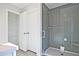 Modern bathroom with tiled shower featuring frameless glass doors and adjacent closet space at 693 Sunstone Ln, Lawrenceville, GA 30043