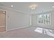 Neutral bedroom featuring a large window and carpet flooring at 693 Sunstone Ln, Lawrenceville, GA 30043