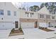 Three well-kept townhouses, showcasing a mix of painted brick and neutral siding, and a one-car garage at 693 Sunstone Ln, Lawrenceville, GA 30043