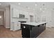 Modern kitchen with white cabinets, a black island, and stainless steel appliances at 693 Sunstone Ln, Lawrenceville, GA 30043