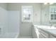 Well-lit bathroom featuring a marble countertop, sink, and a white tub with a shower at 1391 Warrenton Hunt, Lawrenceville, GA 30043