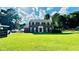 Charming brick home featuring a manicured lawn, mature trees, and classic architectural details at 1391 Warrenton Hunt, Lawrenceville, GA 30043