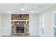 Bright living room featuring a stone fireplace, neutral walls and trim, and modern ceiling fan at 1391 Warrenton Hunt, Lawrenceville, GA 30043