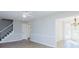 Open-concept living room with staircase, new floors, and elegant chandelier in the adjacent dining area at 1391 Warrenton Hunt, Lawrenceville, GA 30043