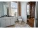 Sunlit bathroom featuring exposed brick, modern vanity, and toilet next to a window with a lovely outdoor view at 1596 Cleveland Ave # 301, East Point, GA 30344