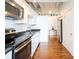 Galley kitchen featuring modern stainless appliances and granite countertops with sleek white cabinets at 1596 Cleveland Ave # 301, East Point, GA 30344