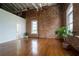 Open living room with hardwood flooring, exposed brick, and bright, natural light at 1596 Cleveland Ave # 301, East Point, GA 30344