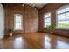 Spacious living room with hardwood floors, exposed brick wall and large windows providing natural light at 1596 Cleveland Ave # 301, East Point, GA 30344