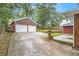 Features a long concrete driveway with a two-car garage, landscaping, and brick on the house at 2057 Cambridge Ave, Atlanta, GA 30337