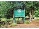 Green sign among lush trees marking the entry to Barrett Park at 2057 Cambridge Ave, Atlanta, GA 30337