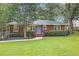 Well-maintained brick home showcasing a green lawn and manicured shrubbery at 2057 Cambridge Ave, Atlanta, GA 30337