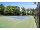 View of community tennis courts surrounded by tall trees and fencing at 2057 Cambridge Ave, Atlanta, GA 30337