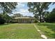 Spacious backyard featuring a lush lawn, mature trees, and a charming sunroom creating a private and serene outdoor space at 2466 Country Club Dr, Conyers, GA 30013