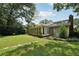 Large backyard featuring lush lawn, mature trees, stone walkway and sunroom for a serene and private space at 2466 Country Club Dr, Conyers, GA 30013