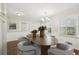 Bright dining room featuring wood floors, wainscoting and a modern chandelier over an oval wood table at 2466 Country Club Dr, Conyers, GA 30013