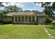 The back of this charming home features a screened in porch, a brick chimney, and a luscious green backyard at 2466 Country Club Dr, Conyers, GA 30013