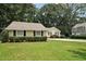 Well-kept yellow home featuring neat landscaping and lush green grass at 2466 Country Club Dr, Conyers, GA 30013
