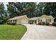 Charming yellow home featuring an attached garage, well-maintained lawn, and lengthy driveway at 2466 Country Club Dr, Conyers, GA 30013