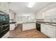Spacious kitchen featuring white cabinets, laminate floors and black appliances at 2466 Country Club Dr, Conyers, GA 30013