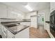 Bright kitchen with laminate floors, white cabinets and eat-in breakfast bar at 2466 Country Club Dr, Conyers, GA 30013