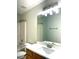 Bright bathroom with vanity, sink, large mirror, and shower at 3884 Grovemont Pl, Duluth, GA 30096