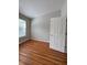 An airy bedroom with a six panel door, light walls, and natural light at 3884 Grovemont Pl, Duluth, GA 30096