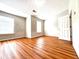 Bright bedroom with two windows, wood floors, and a white six-panel door at 3884 Grovemont Pl, Duluth, GA 30096