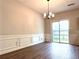 Dining room with dark hardwood floors, a chandelier, and sliding glass doors to the backyard at 3884 Grovemont Pl, Duluth, GA 30096