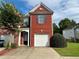 Charming brick townhome featuring a one-car garage and beautifully manicured landscaping at 3884 Grovemont Pl, Duluth, GA 30096