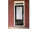 A black front door with glass panels is set into the brick facade with white trim at 3884 Grovemont Pl, Duluth, GA 30096