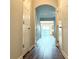 Hallway with arched doorway, leading to an open concept living space and vinyl plank flooring at 3884 Grovemont Pl, Duluth, GA 30096