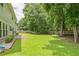 Large backyard with lush lawn, privacy fence, mature trees, and a patio at 5077 Wellisford Ct, Suwanee, GA 30024
