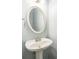 Bathroom featuring a pedestal sink and oval mirror at 5077 Wellisford Ct, Suwanee, GA 30024