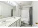 Bright bathroom featuring double sinks, tub, shower, and gray wood-look flooring at 5077 Wellisford Ct, Suwanee, GA 30024