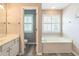 Bathroom featuring a bathtub, vanity, and wood-look flooring at 5077 Wellisford Ct, Suwanee, GA 30024