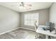 Bedroom with gray walls, wood-look flooring, and desk with dual monitors at 5077 Wellisford Ct, Suwanee, GA 30024