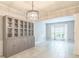 Spacious dining area with built-in cabinet, tile floors, chandelier, and ample natural light at 5077 Wellisford Ct, Suwanee, GA 30024