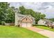 Traditional two-story home with brick and siding exterior, two-car garage, and manicured lawn at 5077 Wellisford Ct, Suwanee, GA 30024