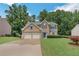 Traditional two-story brick home with a well-maintained lawn, mature trees, and a two-car garage at 5077 Wellisford Ct, Suwanee, GA 30024