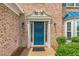 Close-up of a blue front door framed by sidelights and decorative molding, set in a classic brick facade at 5077 Wellisford Ct, Suwanee, GA 30024