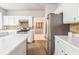 An open concept kitchen featuring white cabinets and stainless steel appliances at 5077 Wellisford Ct, Suwanee, GA 30024