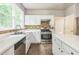 A well-lit kitchen with white cabinets and stainless steel appliances at 5077 Wellisford Ct, Suwanee, GA 30024