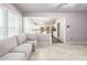 Open living room featuring tile floors, a gray couch, and open view into the kitchen at 5077 Wellisford Ct, Suwanee, GA 30024