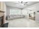 Open concept living room with tile floors, cozy sofa and view to the kitchen at 5077 Wellisford Ct, Suwanee, GA 30024