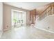 Neutral living room featuring tiled flooring, bay window, and open staircase providing comfort and elegance at 5077 Wellisford Ct, Suwanee, GA 30024