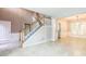 Bright living room with tiled floors, staircase, and open access to other rooms creating an open plan at 5077 Wellisford Ct, Suwanee, GA 30024