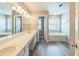 Bright bathroom with double vanity, tub, and wood-look flooring at 5077 Wellisford Ct, Suwanee, GA 30024