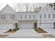 New townhome construction with brick and painted exteriors, garages and sidewalks at 697 Sunstone Ln, Lawrenceville, GA 30043
