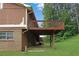Backyard with wooden deck, brick siding, and lush green grass at 115 Elizabeth Way, Ellenwood, GA 30294