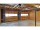 Unfinished basement with exposed ceiling, wood walls and two garage doors at 115 Elizabeth Way, Ellenwood, GA 30294